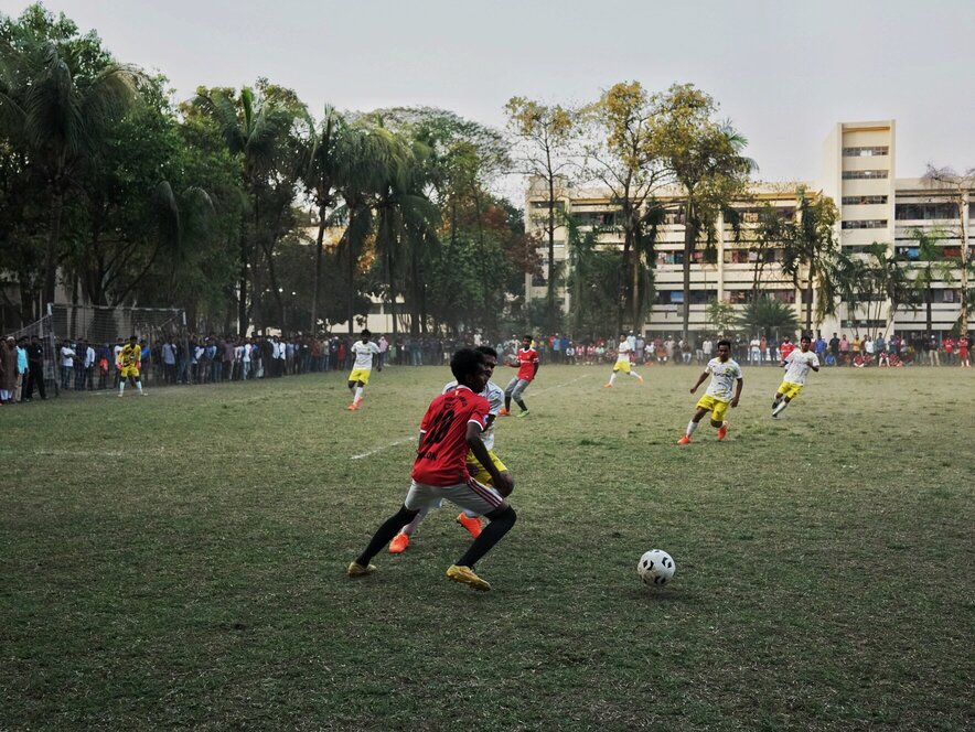 A university athlete, playing football, dribbling