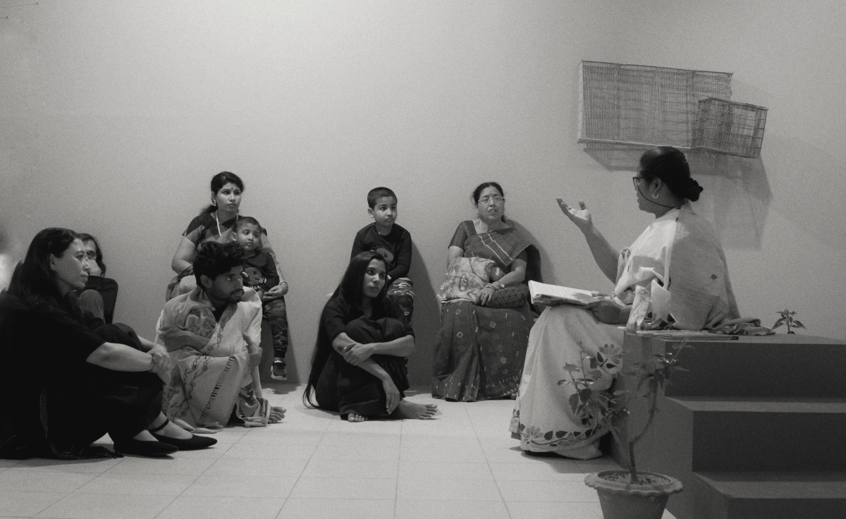 A middle-age woman, telling stories from a book, in Dhaka Art Summit, 2023!
